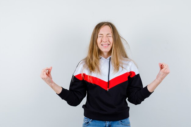 Jeune femme blonde dans une veste et un jean