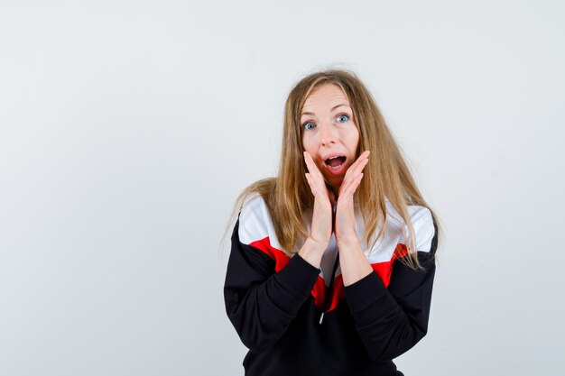 Jeune femme blonde dans une veste et un jean