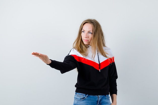 Jeune femme blonde dans une veste et un jean