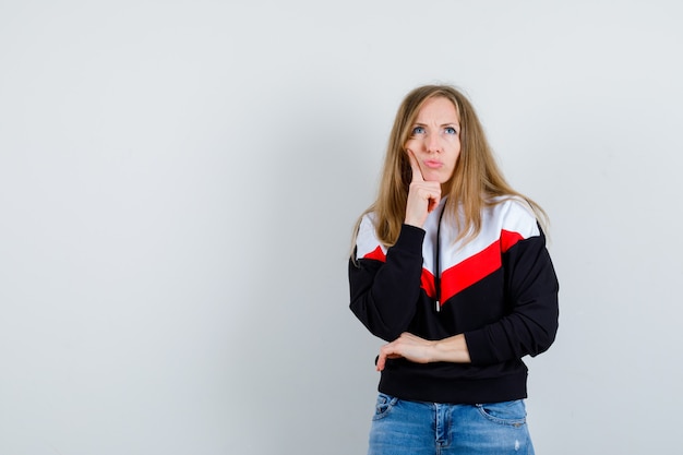 Jeune femme blonde dans une veste et un jean