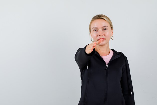 Jeune femme blonde dans une veste noire