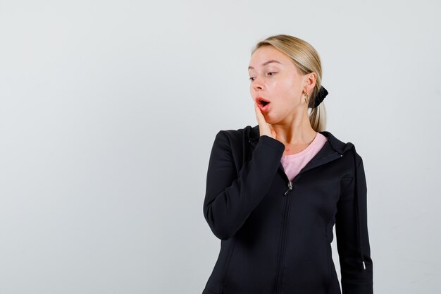 Jeune femme blonde dans une veste noire