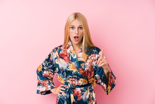 Jeune femme blonde portant un pyjama kimono ayant une idée, un concept d'inspiration.