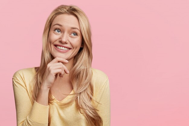 Jeune femme blonde avec pull jaune