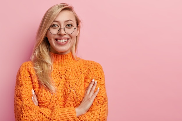 Jeune femme blonde en pull orange