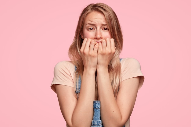 Jeune femme blonde avec une salopette en denim