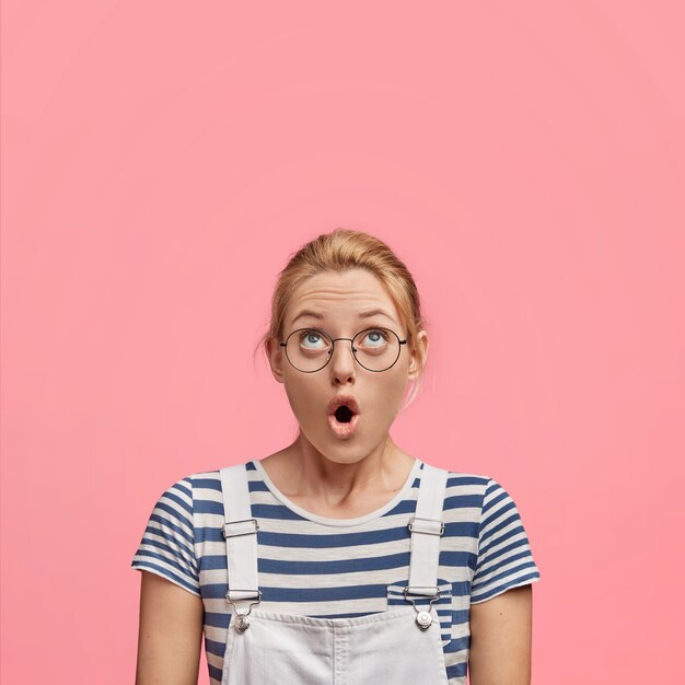 Jeune femme blonde en salopette et t-shirt rayé