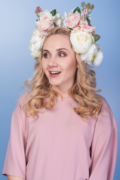 Jeune femme blonde surprise avec une belle couronne de fleurs