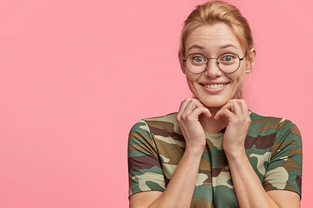 Jeune femme blonde en T-shirt camouflage