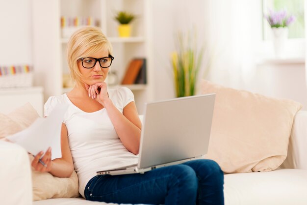 Jeune femme blonde travaillant à la maison