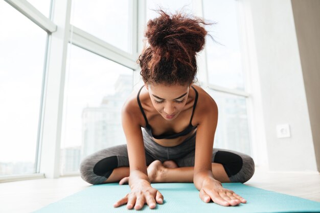 Jeune femme en bonne santé, assis en posture de lotus et faire de l'exercice