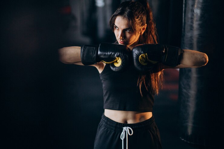 Photo gratuit jeune femme boxeur s'entraînant au gymnase