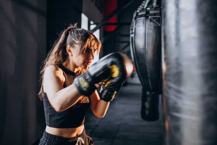 Photo gratuit jeune femme boxeur s'entraînant au gymnase