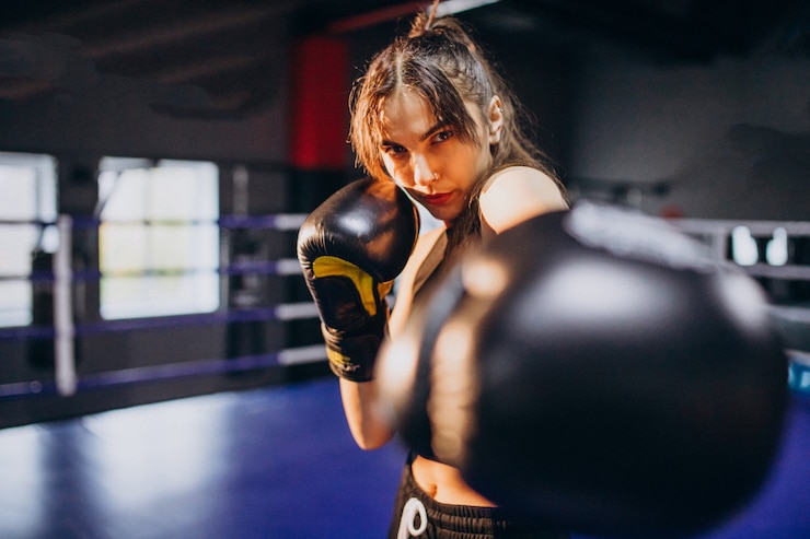 Photo gratuit jeune femme boxeur s'entraînant au gymnase