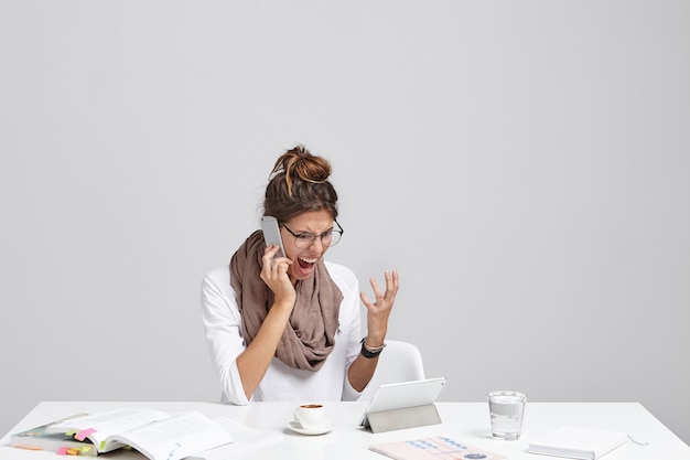 Jeune femme brune assise au bureau