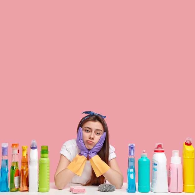 Jeune femme brune assise à côté de produits de nettoyage