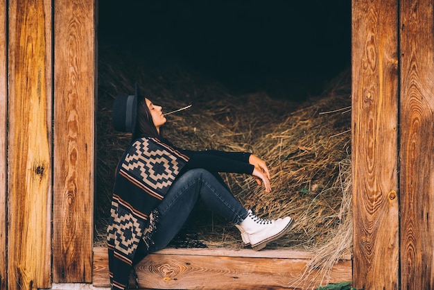 Photo gratuite jeune femme brune assise à la grange country style