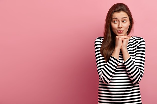 Jeune femme brune en chemise rayée