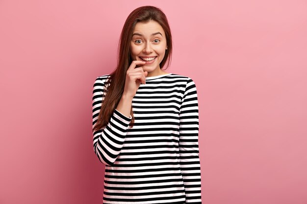 Jeune femme brune en chemise rayée