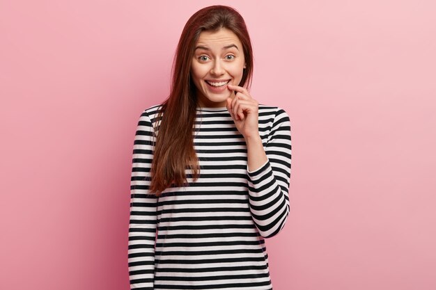 Jeune femme brune en chemise rayée