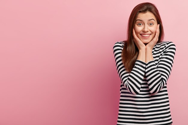 Jeune femme brune en chemise rayée