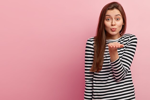 Jeune femme brune en chemise rayée