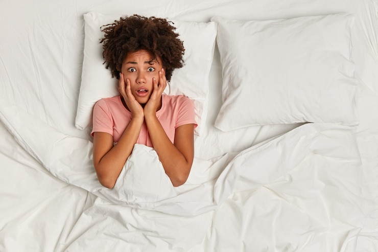 Photo gratuit jeune femme brune couchée dans son lit