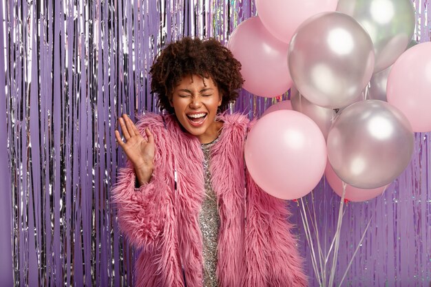 Jeune femme brune à la fête tenant des ballons