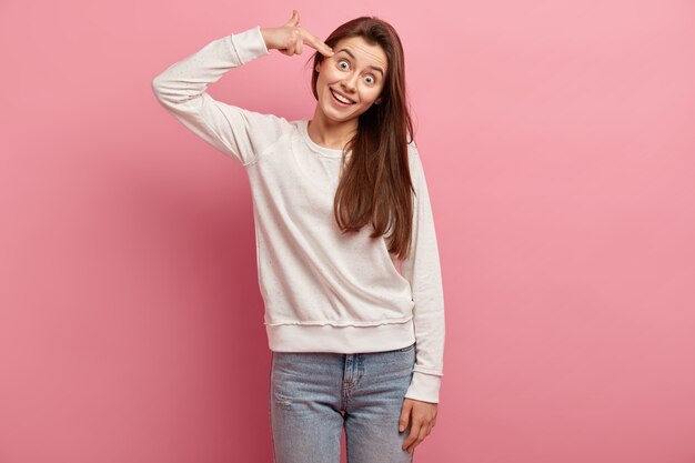 Jeune femme brune en jeans et pull