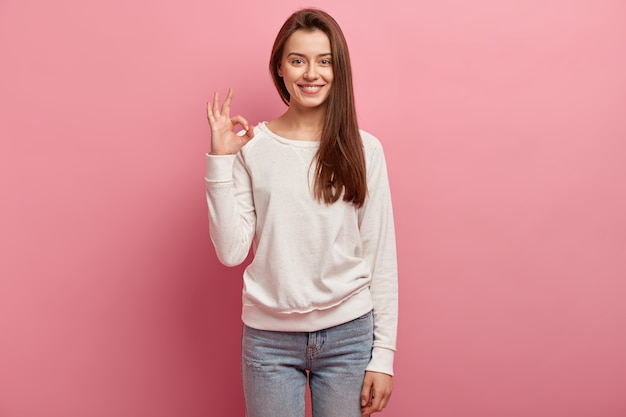 Jeune femme brune en jeans et pull