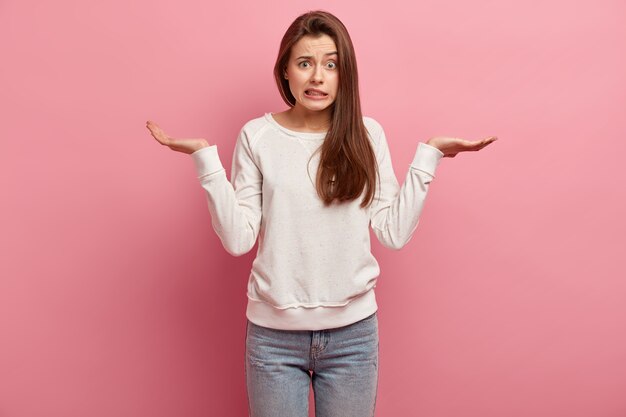 Jeune femme brune en jeans et pull