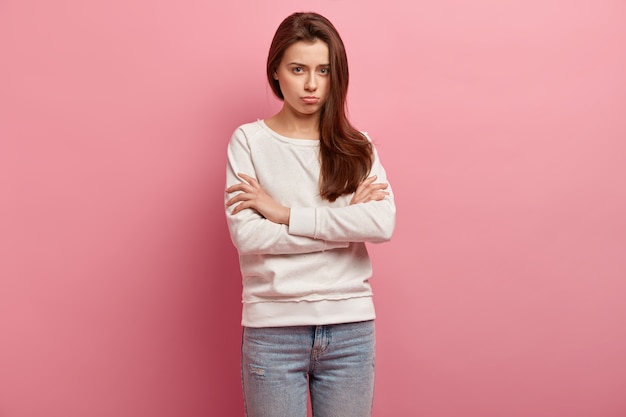 Jeune femme brune en jeans et pull