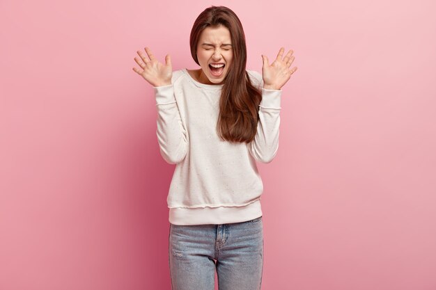 Jeune femme brune en jeans et pull