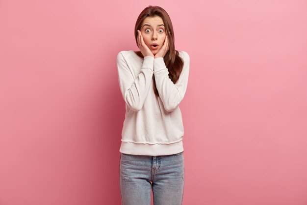 Jeune femme brune en jeans et pull