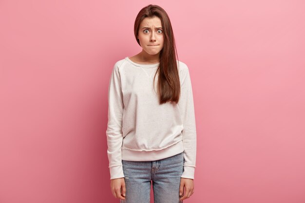 Jeune femme brune en jeans et pull