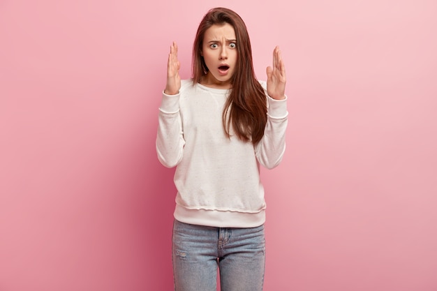 Jeune femme brune en jeans et pull