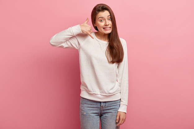 Jeune femme brune en jeans et pull