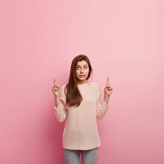 Jeune femme brune en jeans et pull