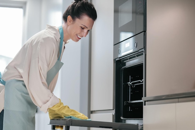 Photo gratuite jeune femme brune nettoyant des appareils de cuisine