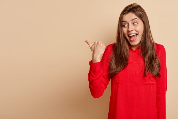 Jeune femme brune portant une chemise rouge