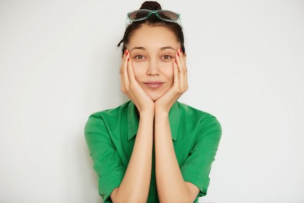 Jeune femme brune portant une chemise verte