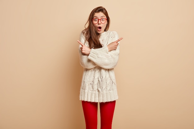 Jeune femme brune portant des lunettes rouges et pull blanc