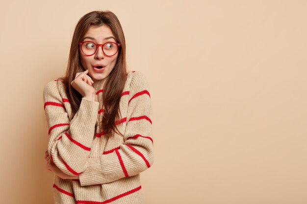 Jeune femme brune portant des lunettes rouges