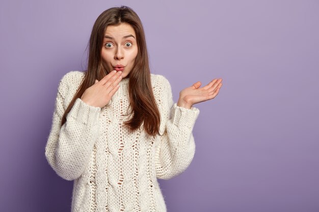 Jeune femme brune portant un pull blanc