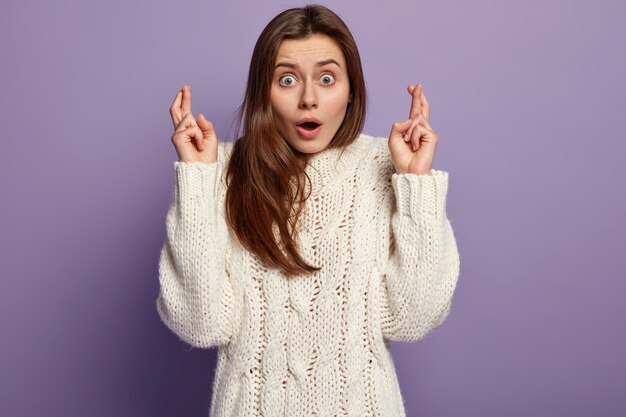 Jeune femme brune portant un pull blanc