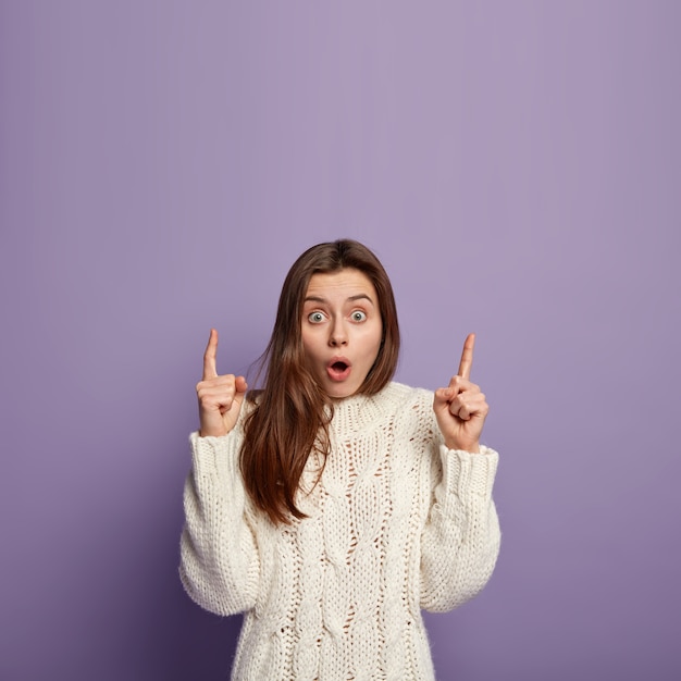 Jeune femme brune portant un pull blanc