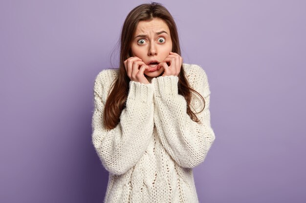 Jeune femme brune portant un pull blanc