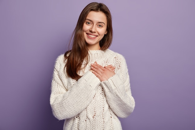 Jeune femme brune portant un pull blanc