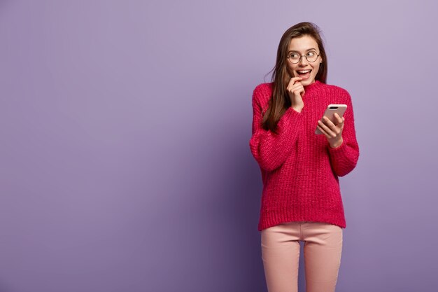 Jeune femme brune portant un pull rouge