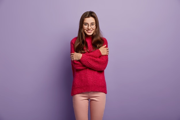 Jeune femme brune portant un pull rouge